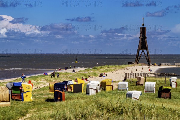 Beach on the North Sea coast with lighthouse and beach chairs under a blue sky, beach chairs on the