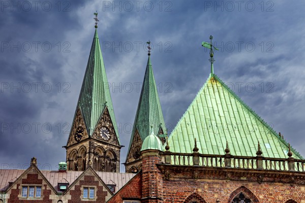 Gothic church towers with green roofs rise against a dramatic cloudy sky, The center of the