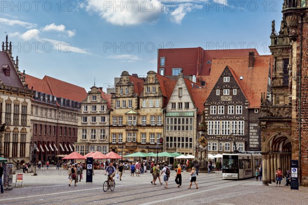 Lively historic old town with half-timbered houses and a tram against a clear blue sky, the center