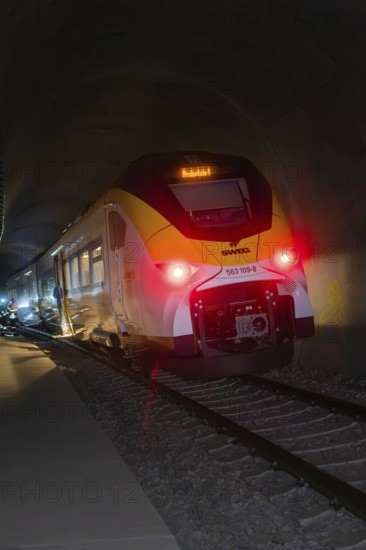 A train with glowing lights goes through a dark tunnel, fire department exercise at the Hermann