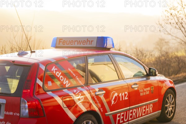 A red fire department car on a country road at sunset, fire department exercise on the Hermann