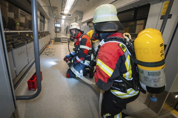 Firefighters inspect the interior of a train in full gear, fire brigade exercise on the Hermann