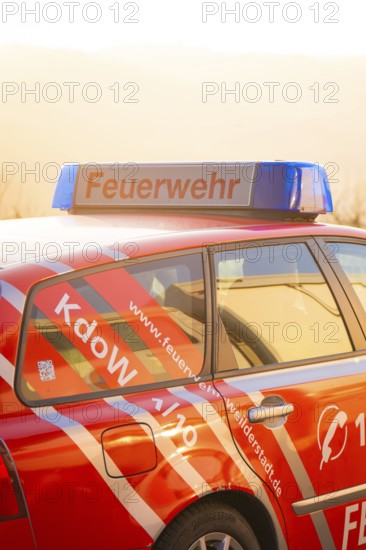 Red fire engine with blue signal light at dusk, fire department exercise on the Hermann Hesse