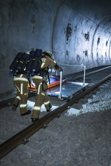 Firefighters push a stretcher on the train tracks in the tunnel, fire department exercise on the