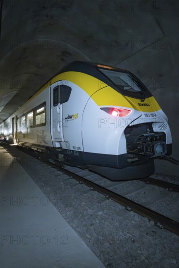 A train with yellow and white colors stands in the tunnel at night, fire department exercise on the