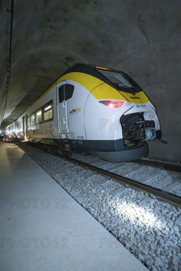 A yellow and white train passes through a tunnel at night, fire department exercise on the Hermann