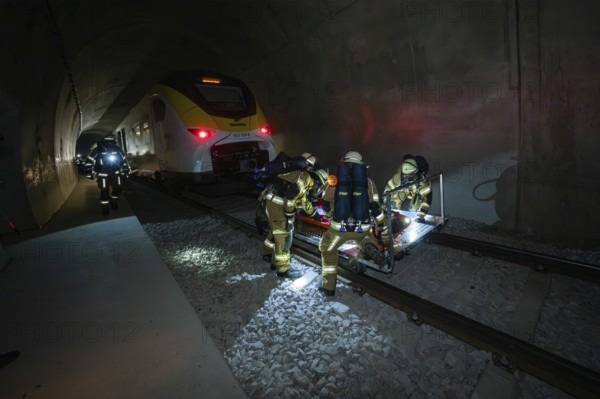 Firefighters rescue a person on the tracks in a tunnel at night, fire brigade exercise on the
