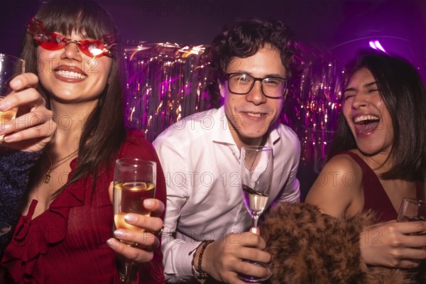 Young friends enjoying a vibrant night out with drinks, smiling and laughing under club lights,
