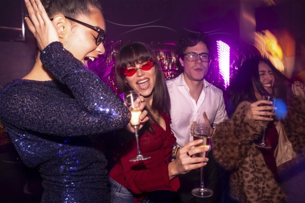 Group of diverse friends celebrating a special occasion, drinking champagne, dancing and having fun