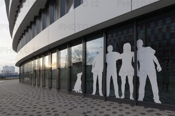 Paper cut family with dog, sticker on window front of an office building, Medienhafen Düsseldorf,
