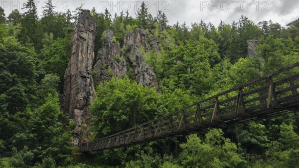 Suspension bridge leads across a river through wooded rocks, Hans Heiling Rocks, Eger Valley, Czech