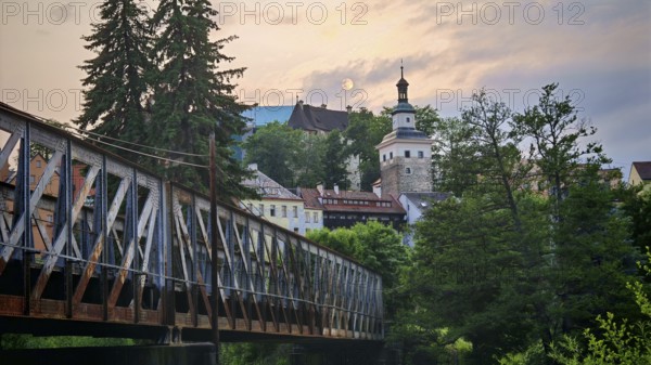 Idyllic city view with old railroad bridge and tower over a river in the evening light, Loket,
