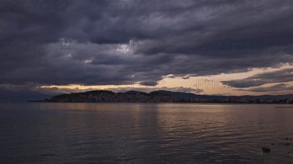 View of a lake at sunset with dramatic clouds covering the sky, Lake Ohrid, North Macedonia