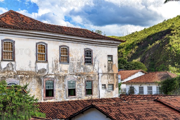 Facade of a historic colonial mansion deteriorated by time in the city of Ouro Preto in Minas