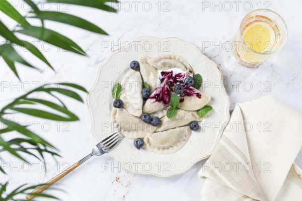 Handmade dumplings filled with sweet ingredients, arranged beautifully on a white plate, topped