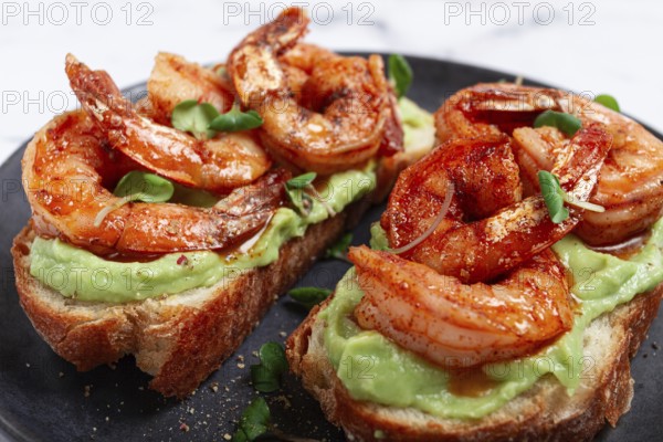 Sandwiches with avocado and caramelized shrimp, micro-greens, breakfast, on a plate, top view,