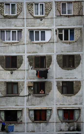 A prefabricated building with symmetrical windows and visible decay that conveys a melancholy urban