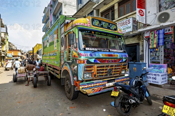 Workers load a truck with large packages on a busy city street, The colorful trucks in the streets