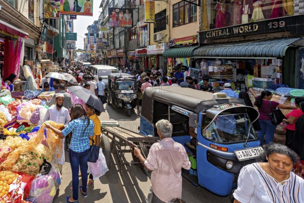 Busy street with market stalls, people and rickshaws in a busy shopping district, the hustle and