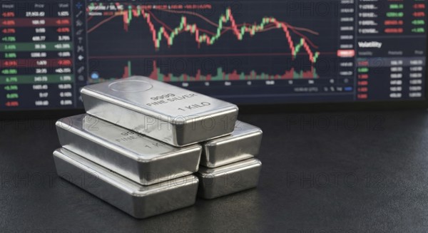 Stacked 99.99% fine silver bars are displayed in front of a digital financial chart, symbolising