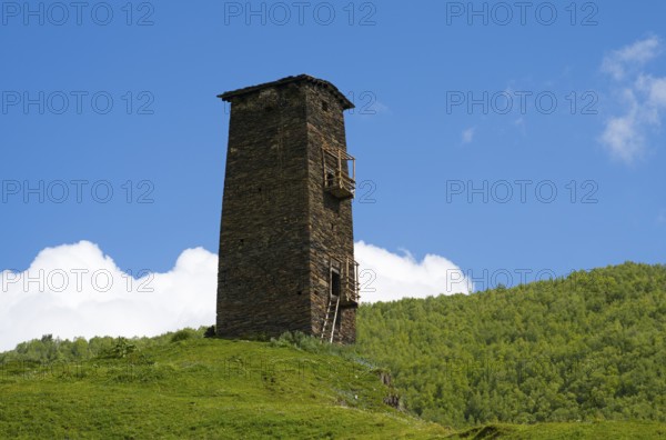 Single old tower on hill with green landscape and cloudy sky, Queen Tamar's tower, Tamara, Ushguli,