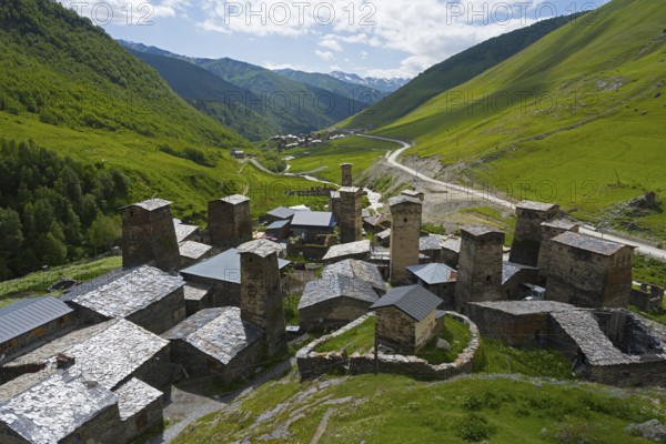 Village with a variety of towers and roofs in a green mountain backdrop, defensive towers, Ushguli,