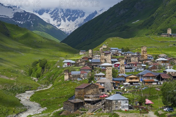 Picturesque village with many towers and houses in a green mountain valley, defensive towers,