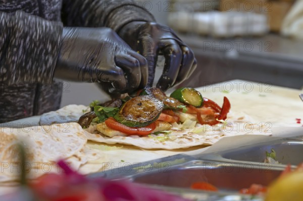 Preparation of falafel with fresh vegetables in a falafel stand in the pedestrian zone, Nuremberg,
