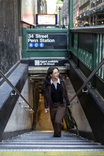 Young businesswoman ascending the stairs from the new york city subway at 34 street penn station,