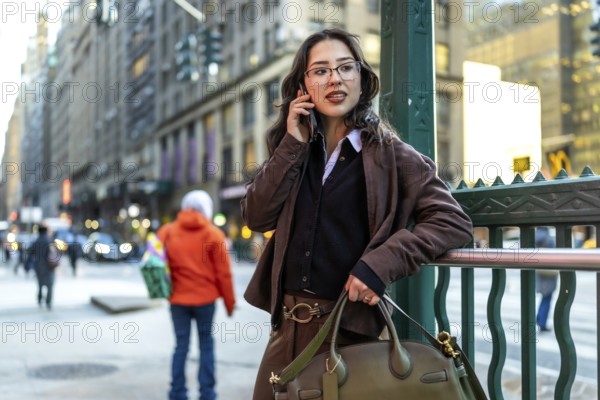 Young businesswoman in manhattan walking and talking on a smartphone, dressed smart casual,