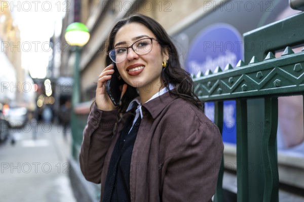 Young businesswoman standing in new york city, actively communicating on her mobile phone while