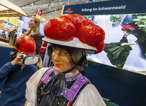 Tradition and progress. A young trade fair visitor wearing 3D glasses next to a model of a woman