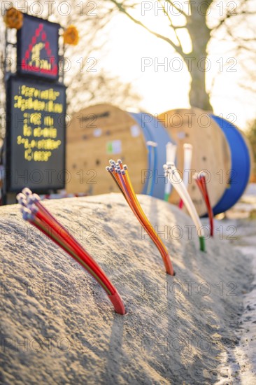 Various thin cables stick out of the ground of a construction site, fiberglass groundbreaking,