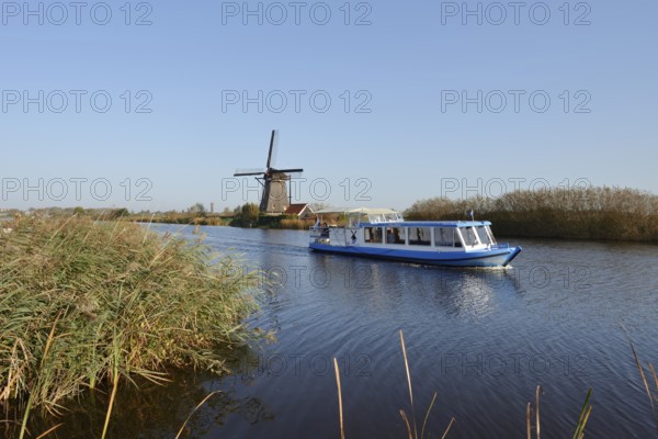 Historic windmill and sightseeing boat, UNESCO World Heritage Site, Kinderdijk, South Holland,
