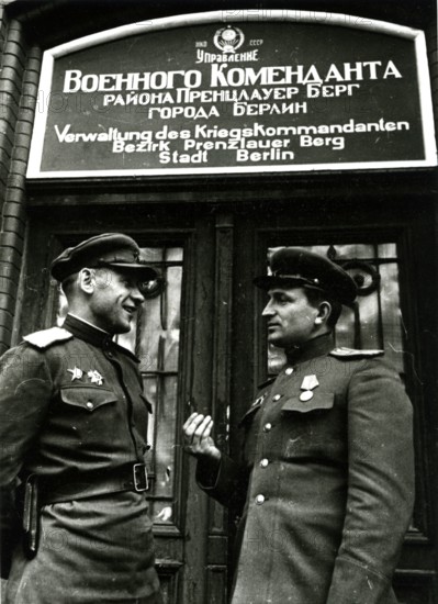 Two Soviet soldiers in front of the administration of the war commander for the district of