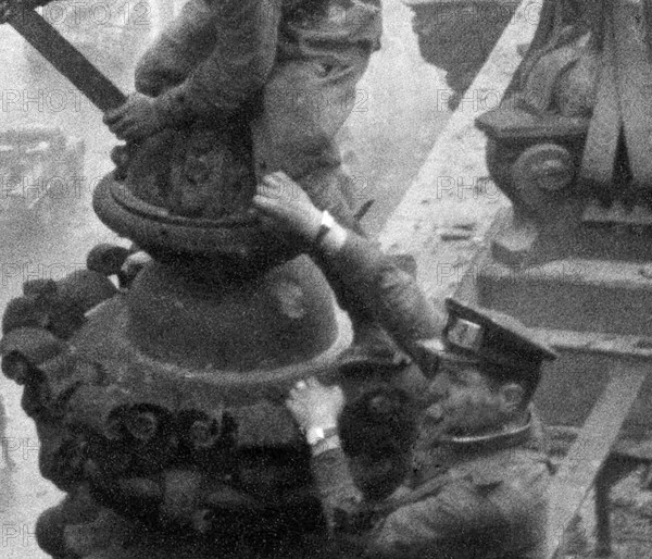 Excerpt from the photo: At the Berlin Reichstag, May 2, 1945, three Soviet soldiers hoist the flag