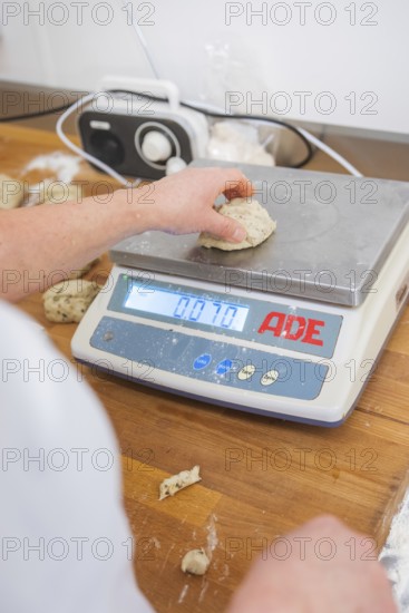 A hand weighs a piece of dough on a digital kitchen scale, bake rolls, Haselstaller Hof, Gechingen,