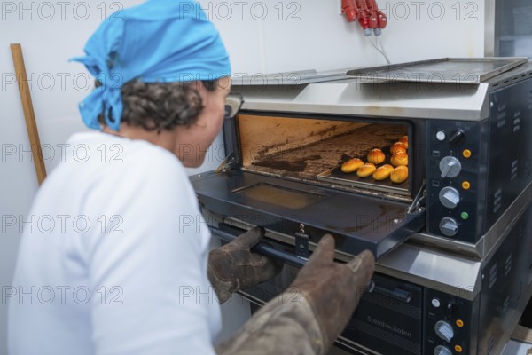 Baker opens oven to take out freshly baked rolls, bake rolls, Haselstaller Hof, Gechingen, Germany