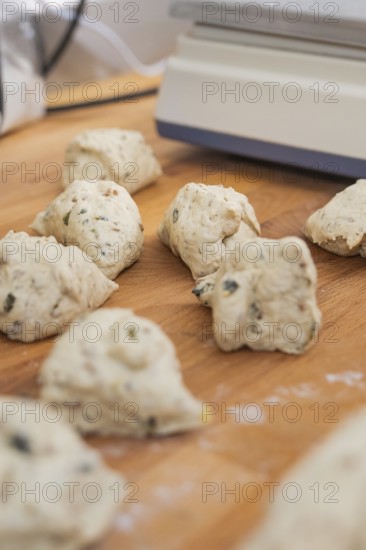 Several small pieces of dough lie on a wooden table to prepare, bake rolls, Haselstaller Hof,