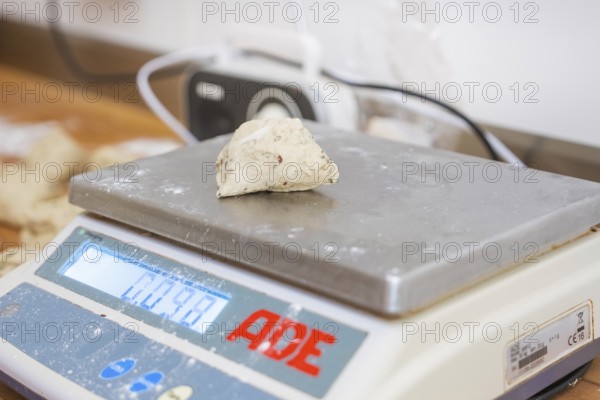 A piece of dough is measured on a digital scale in a bakery, bake rolls, Haselstaller Hof,