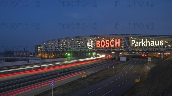 Traffic on the A8 motorway, blue hour, illuminated parking garage, Landesmesse Stuttgart, red-lit