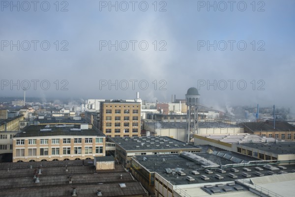 View of the industrial area of Singen am Hohentwiel with industrial buildings and hazy morning sky,