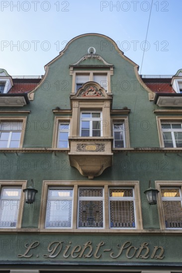 Historic building façade from the Wilhelminian period with green paint and decorative details,