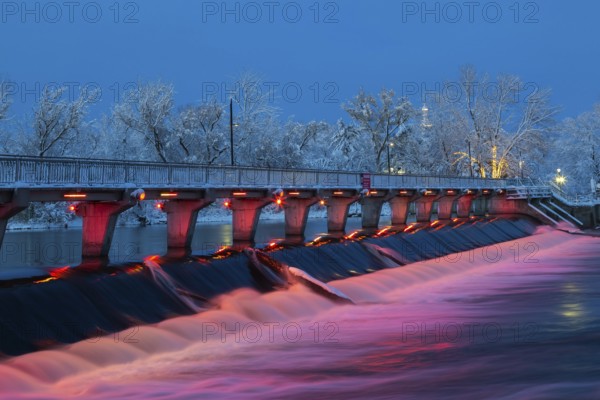 Illuminated Moulin Neuf water flow control dam and walkway over Des Mille-Iles river with first