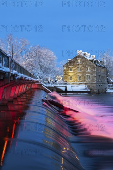 Illuminated Moulin Neuf water flow control dam and walkway over Des Mille-Iles river plus New Mill