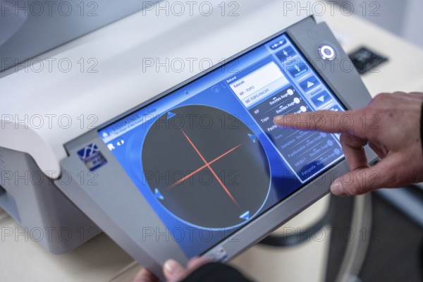 Finger points at the user interface of a medical device, optician, Pforzheim