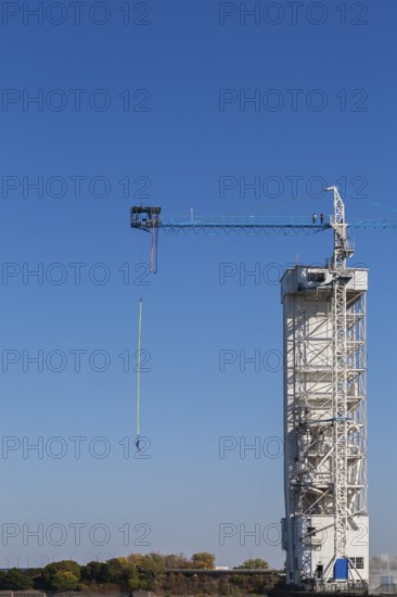 Montreal Bungee Tower with male bungee jumper in midair with his ankles tied to a long yellow