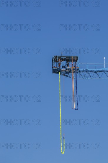 Montreal Bungee Tower installation with dangling long yellow elastic bungee jumping cord and woman