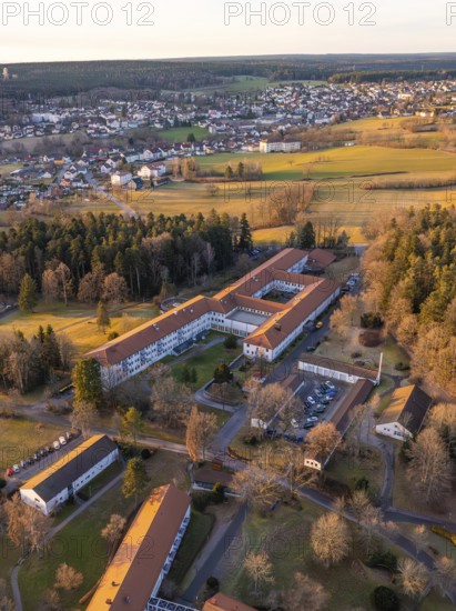 A bird's-eye view of a village with extensive fields and buildings at winter sunset, Rehab Clinic,