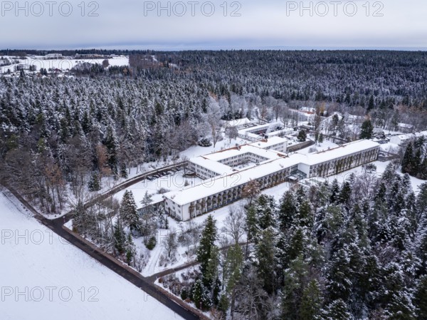 Snowy forest landscape with a large building in the middle, viewed from above, rehab clinic,